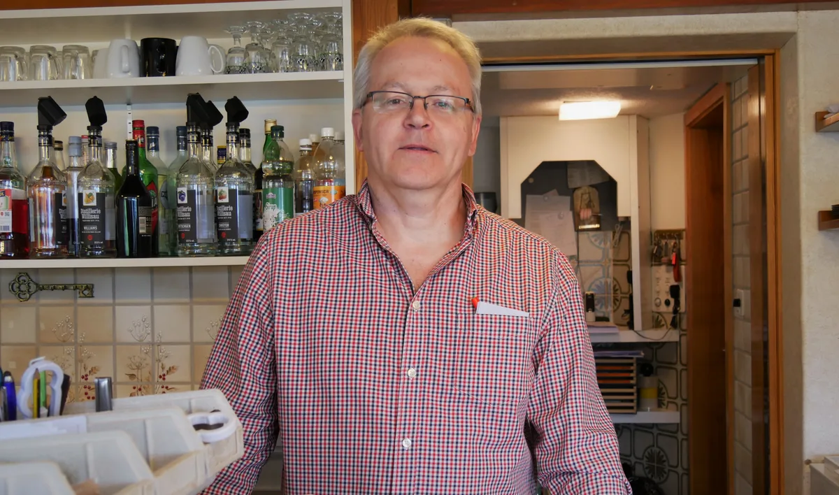 Man sieht einen Restaurantbetreiber hinter dem Tresen.